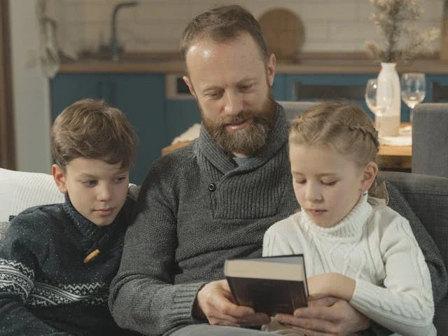man and children reading together