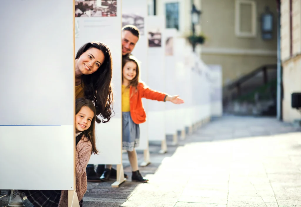 a family playfully posing behind an installation